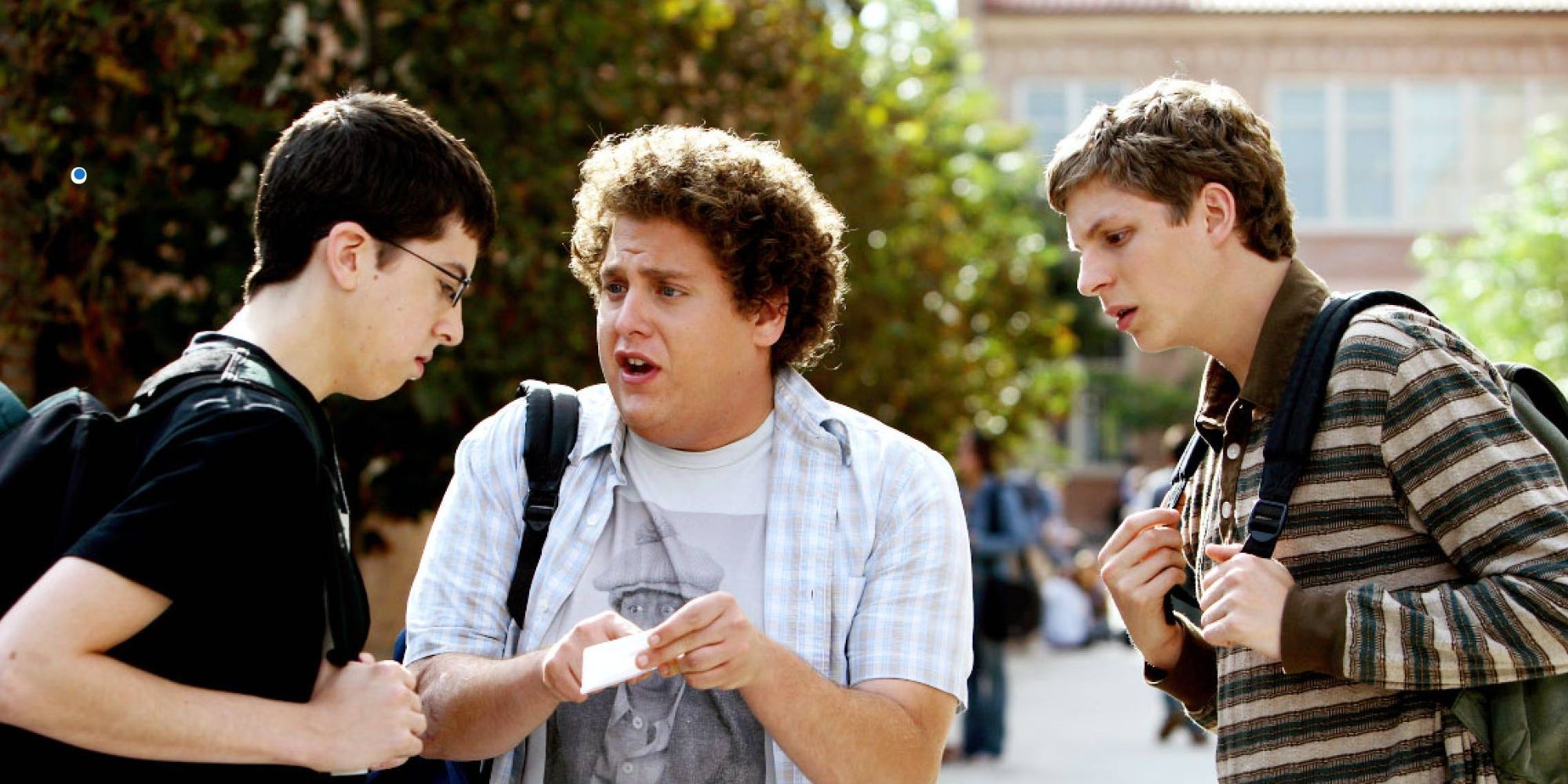 Three teenagers examine a fake ID