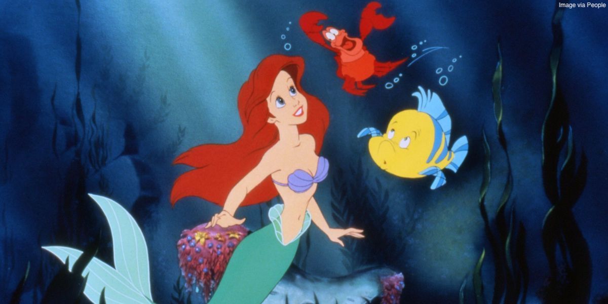 Ariel smiles at Sebastian and Flounder underwater in Disney's The Little Mermaid.