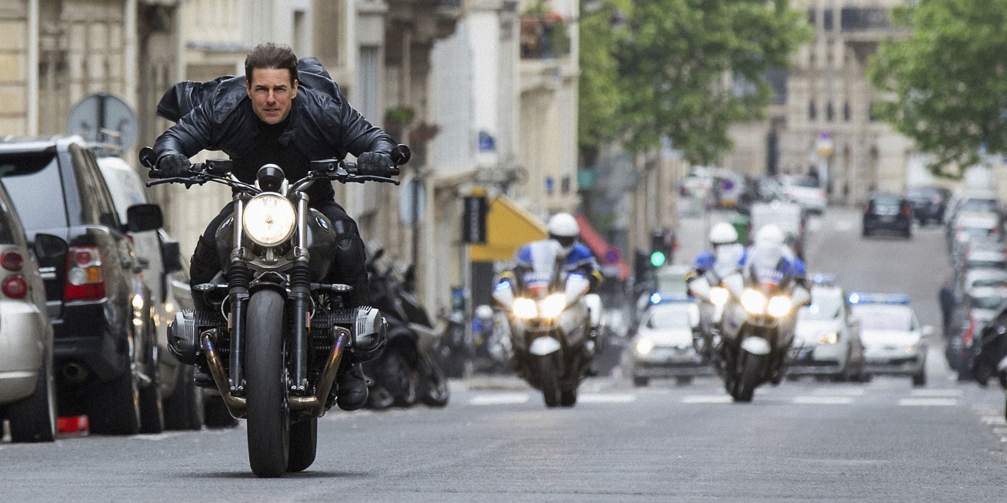 Ethan Hunt (Tom Cruise) rides a motorcycle in Mission: Impossible: Fallout (2014).