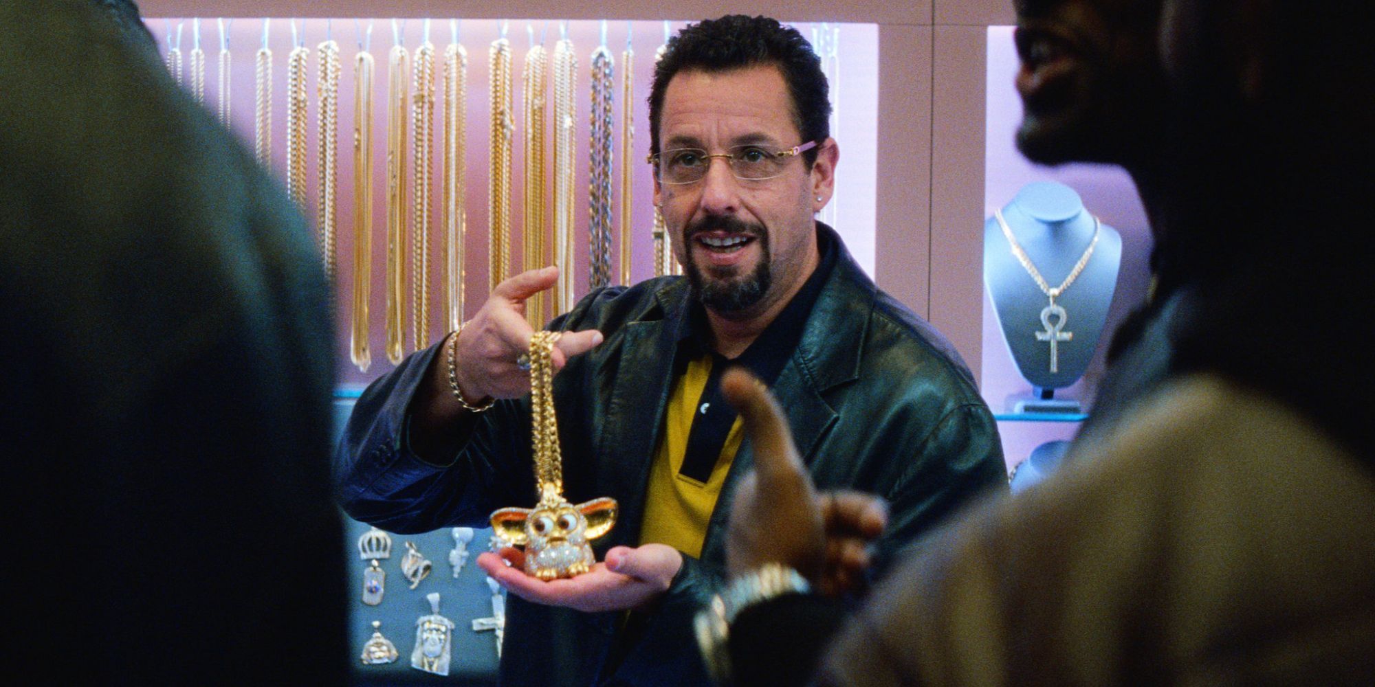 Adam Sandler holding his necklace in Uncut Gems