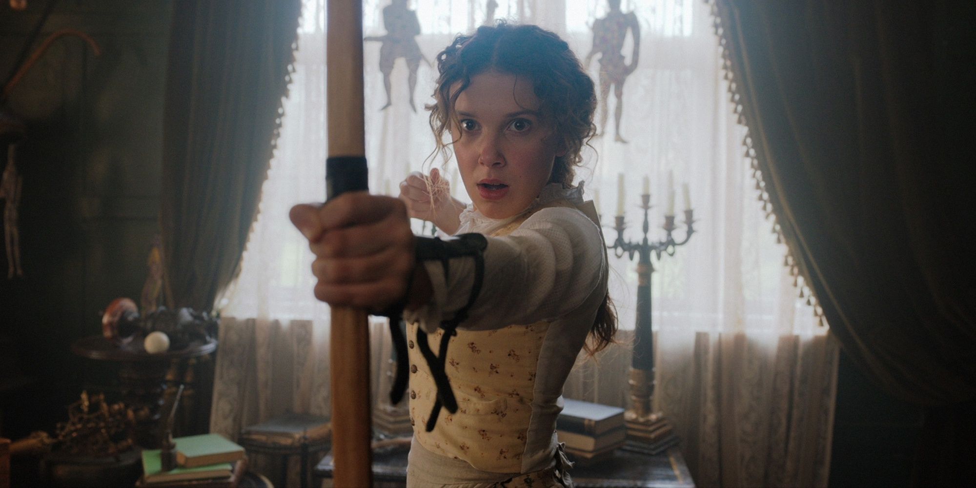 Enola Holmes with a bow and arrow in Enola Holmes 2.