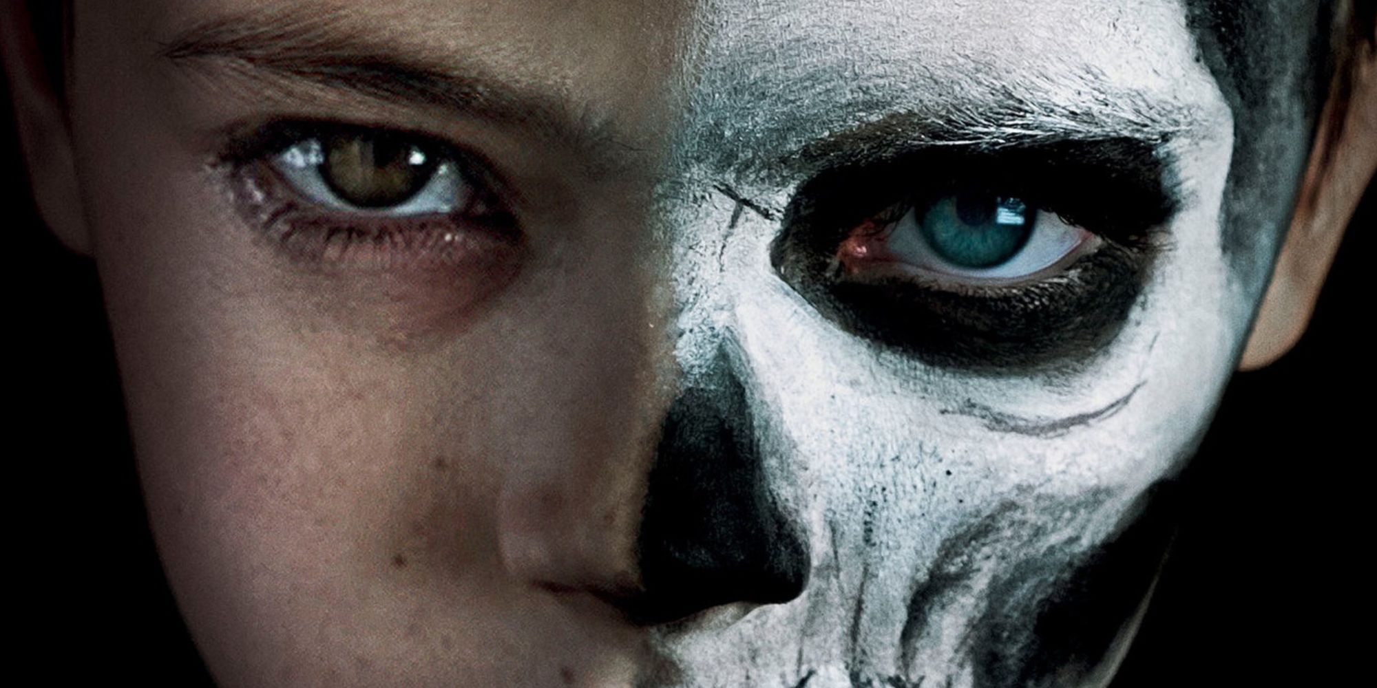 A boy with a face half painted like a skeleton
