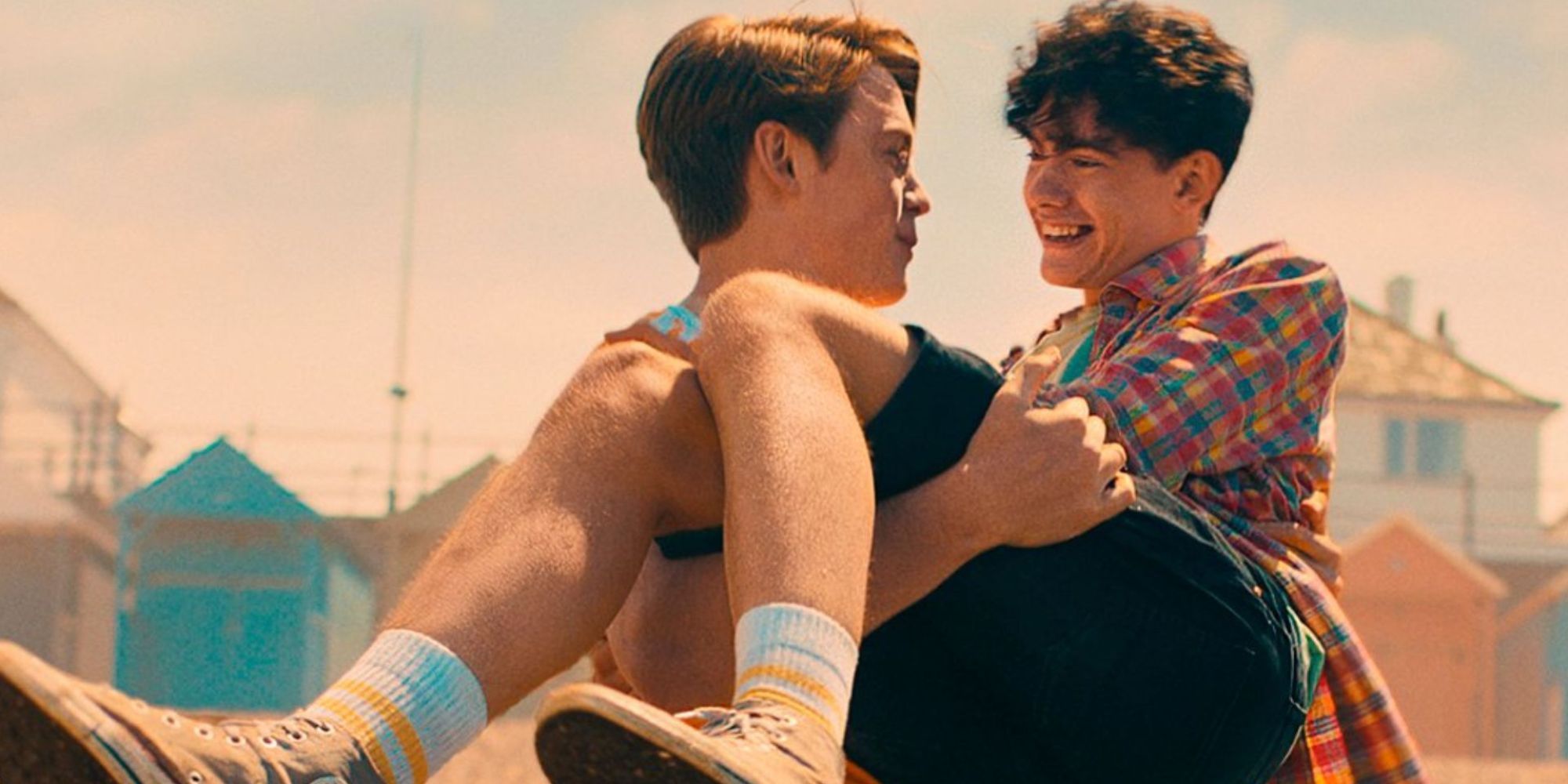 Nick from Heartstopper carries Charlie in his arms on the beach