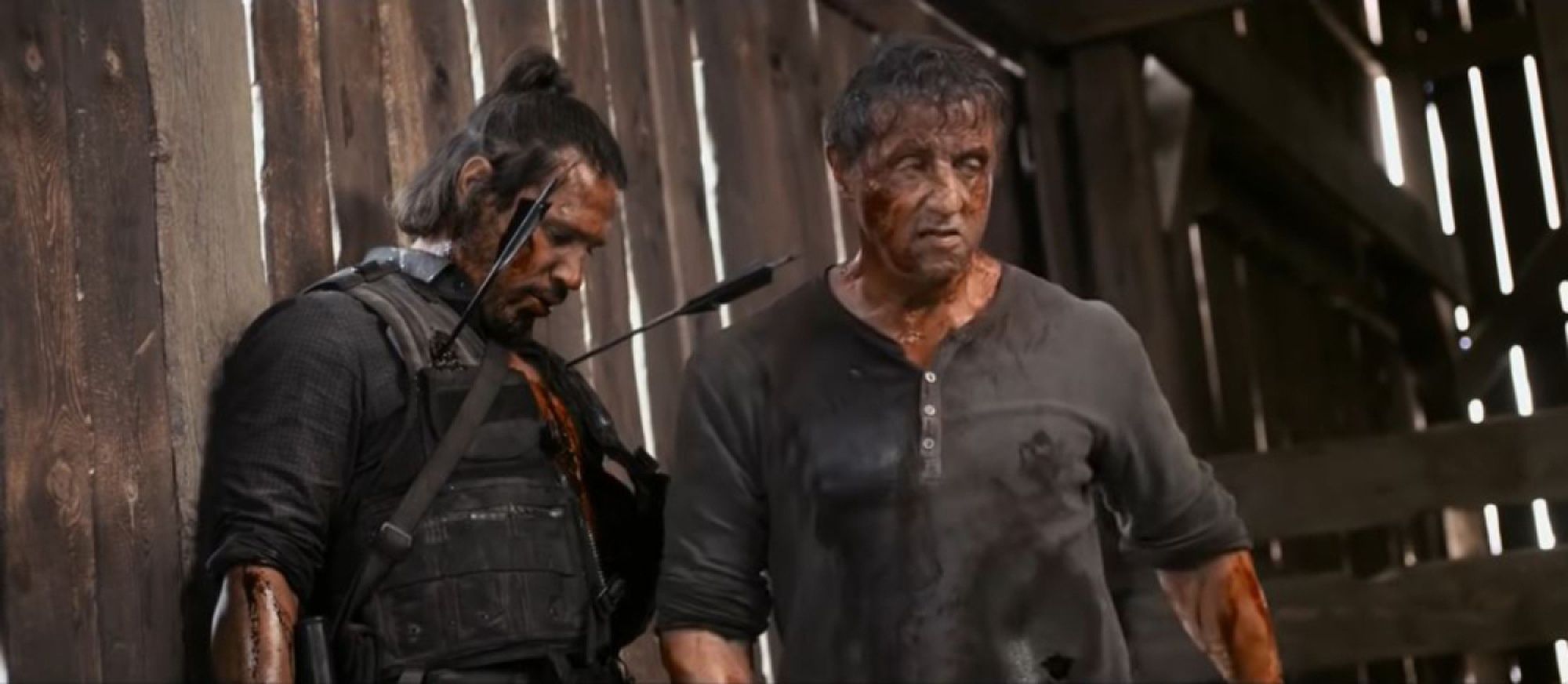 Rambo walks away from the body of a man pierced by arrows to the wall