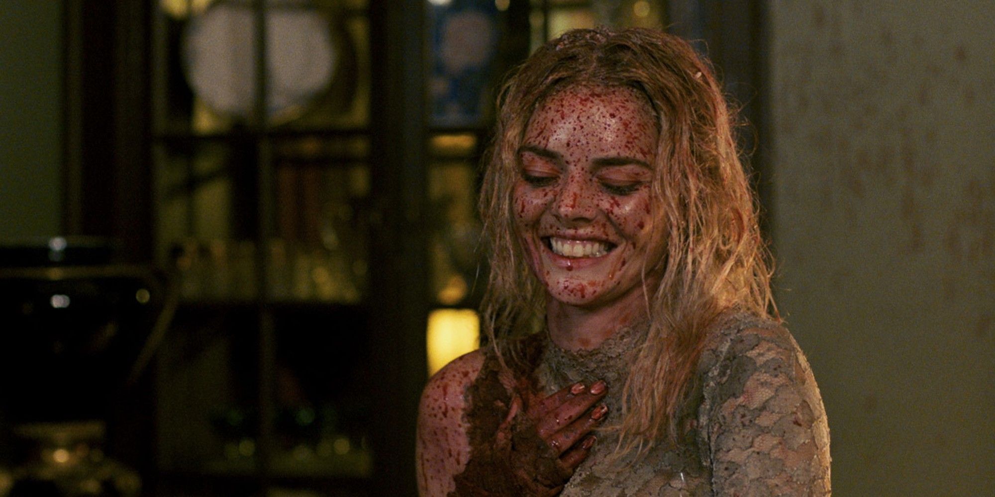 The heroine of Samara Weavering smiles, covered in blood.