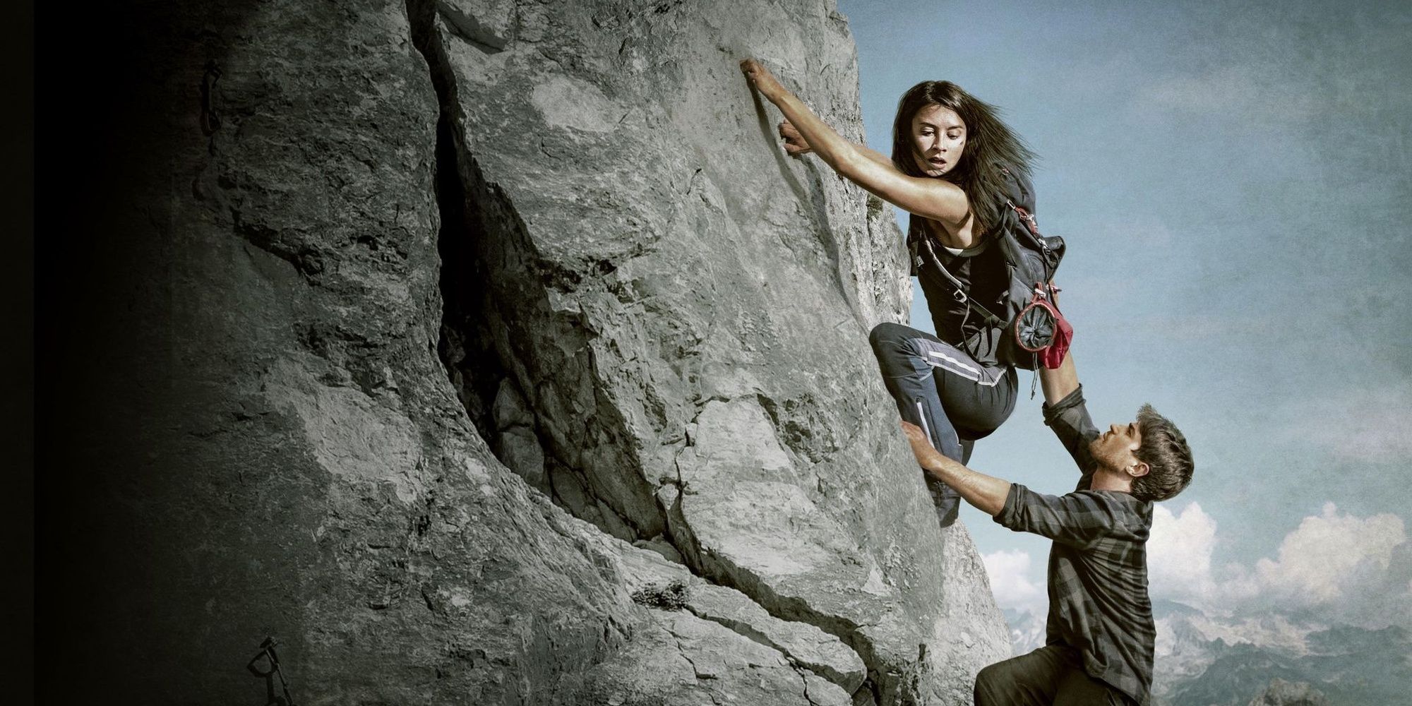 A woman climbs a mountain when a man tries to pull her down