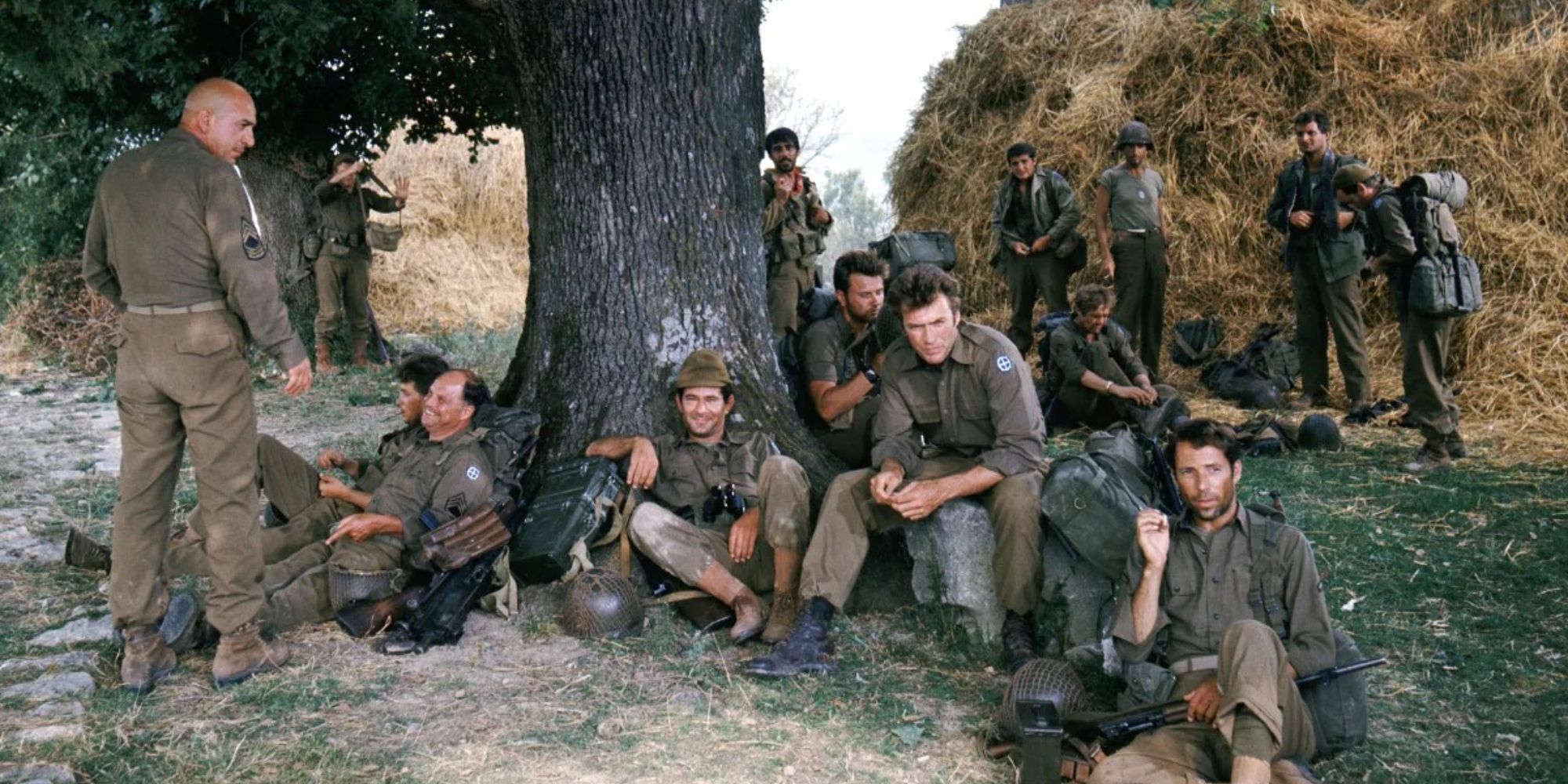 Actors of Kelly's Heroes sit under a tree