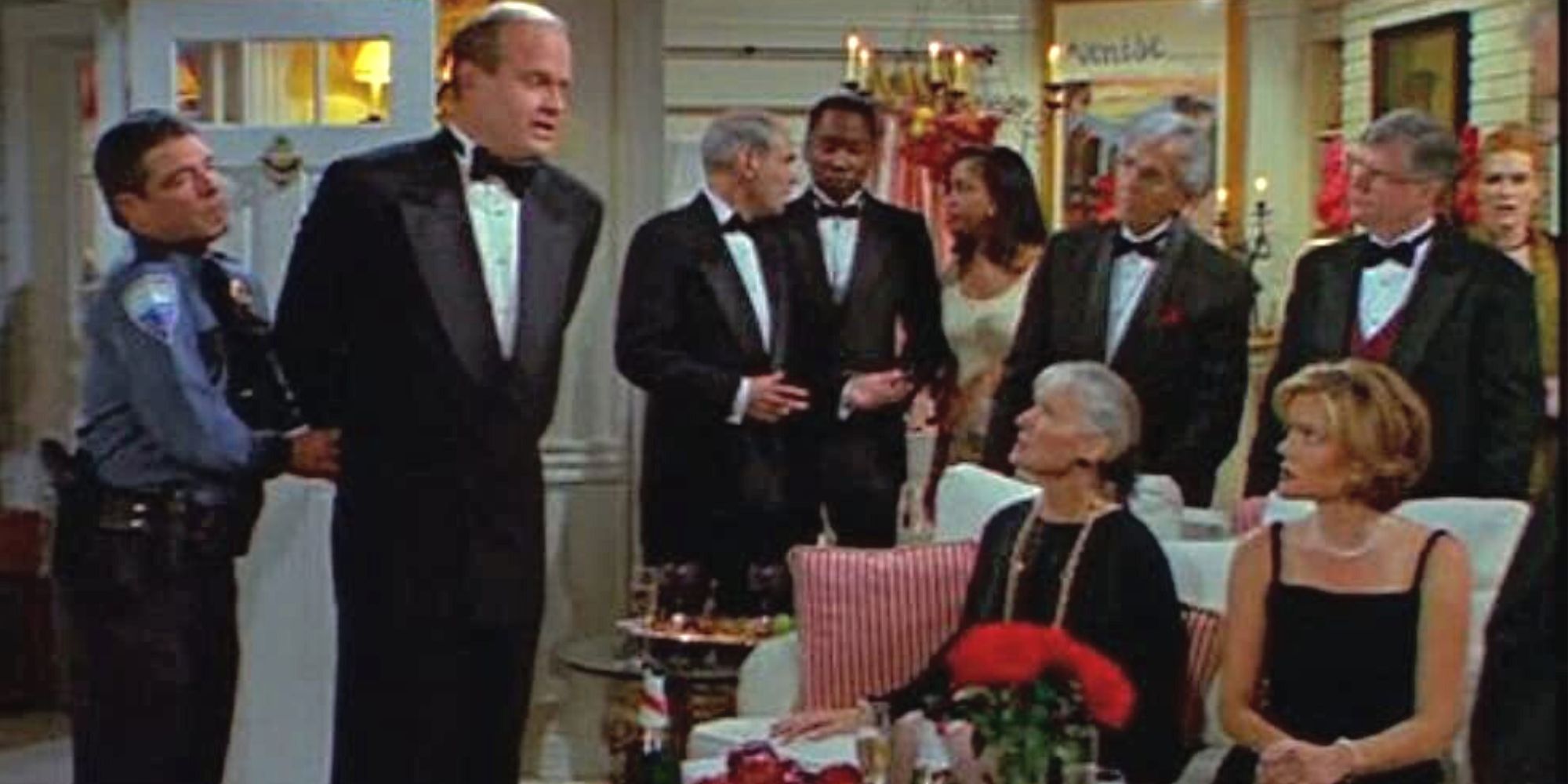 A handcuffed police officer on Kelsey Grammer addresses a group of guests in Fraser 2.