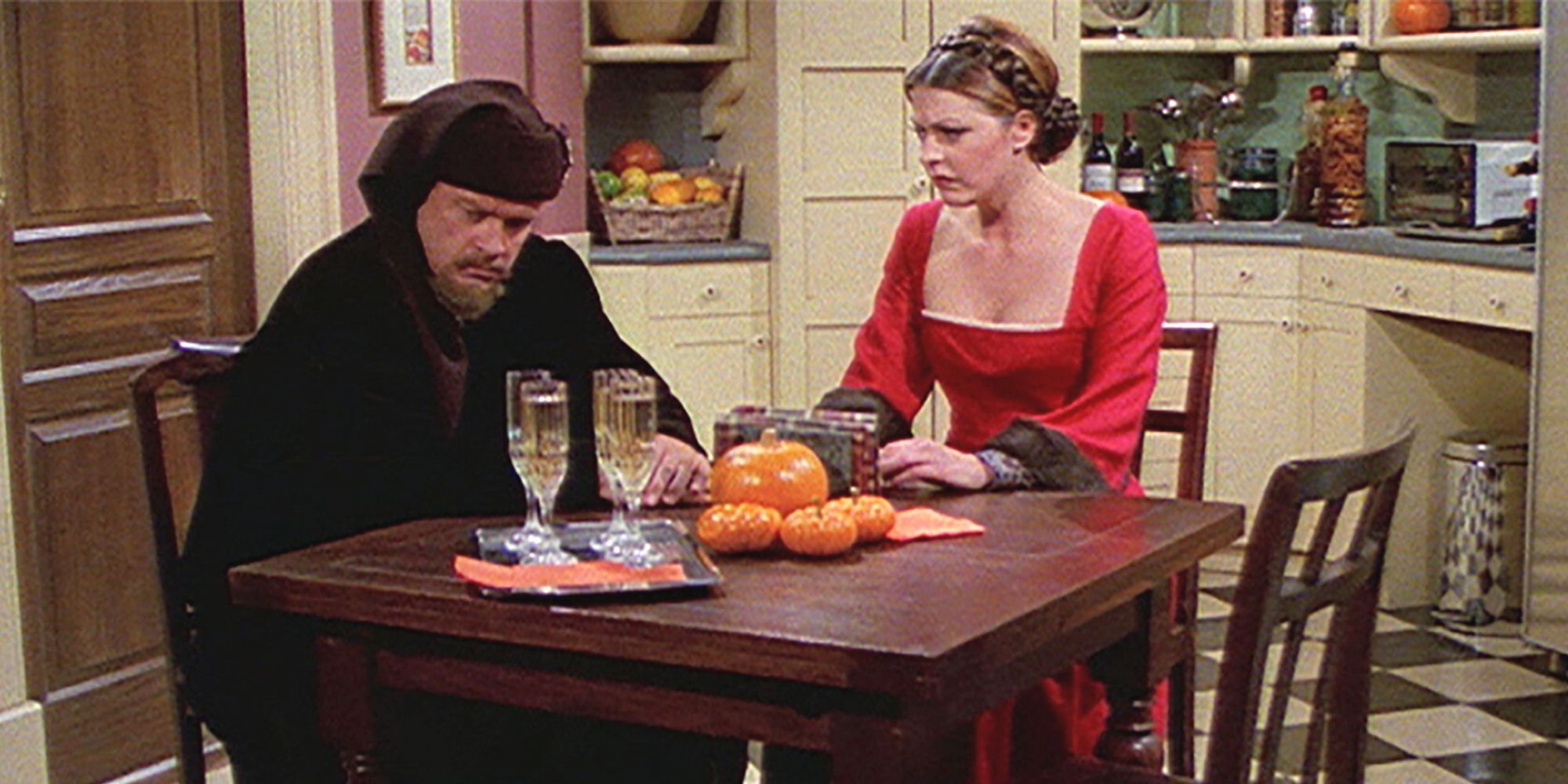 Kelsey Grammer sits at the kitchen table with Jane Leeves in Frasier.