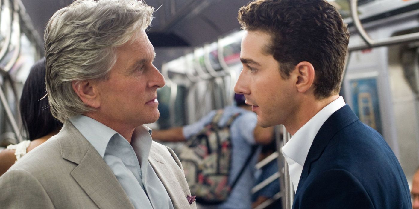 Michael Douglas as Gordon and Shia LaBeouf as Jake stand and talk to each other on the subway in Wall Street: Money Never Sleeps.