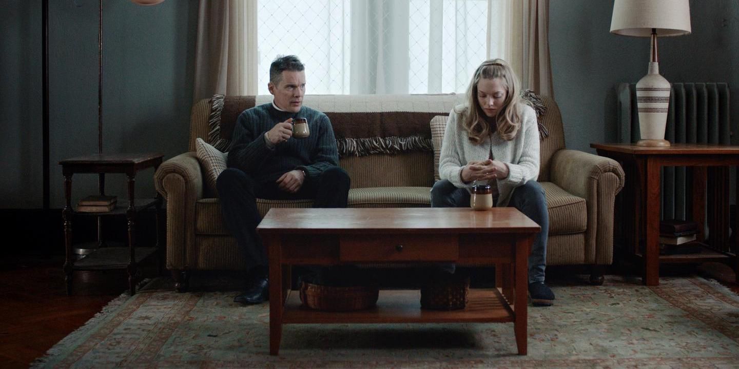 Father Toller and Mary are sitting on the couch drinking coffee together.