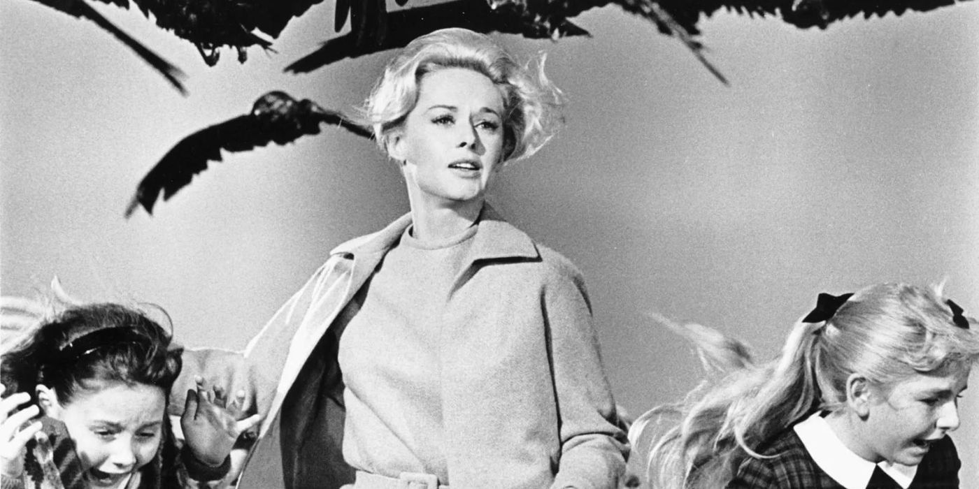 Melanie, played by Tippi Hedren, runs with two little girls from a flock of attacking birds in Alfred Hitchcock's The Birds.
