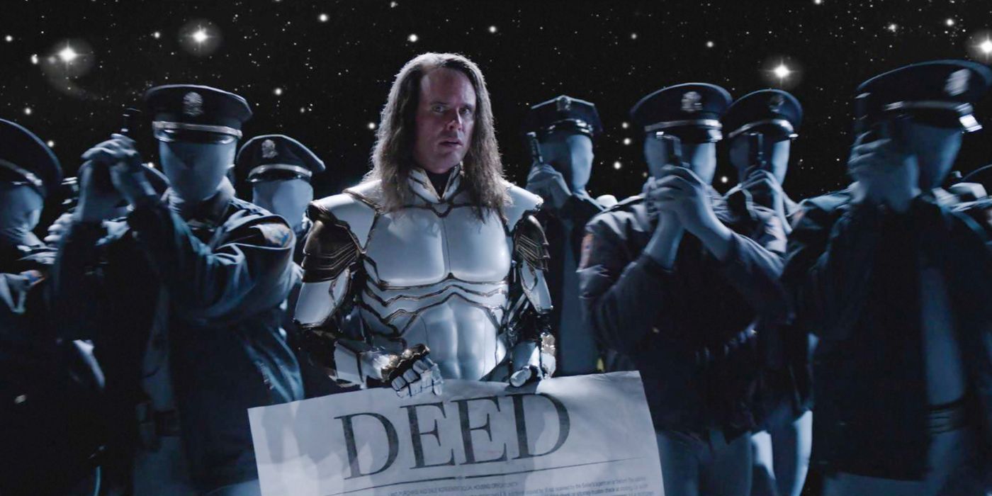 Walton Goggins as the Hero holding a huge feat in I Am a Virgin