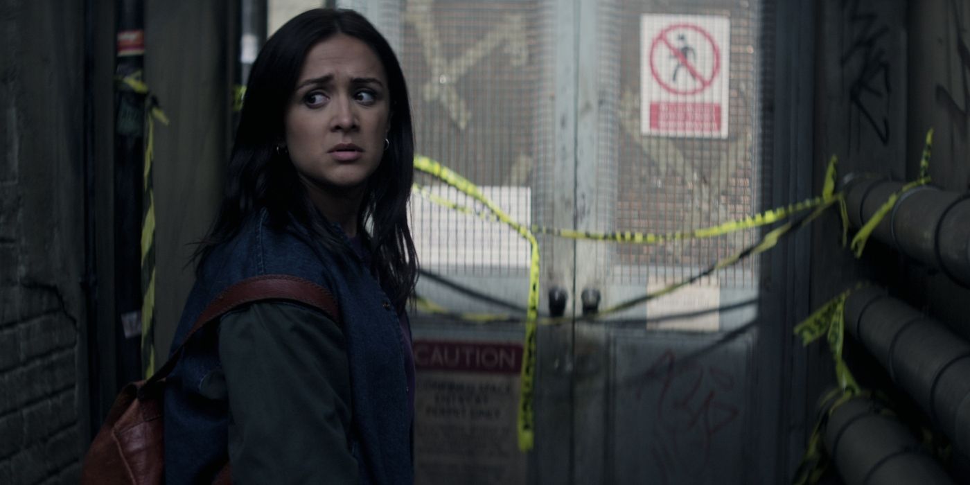 Nadia, played by Amy-Lee Hickman, backpacks and looks back anxiously in front of a sealed door in season 4's You.