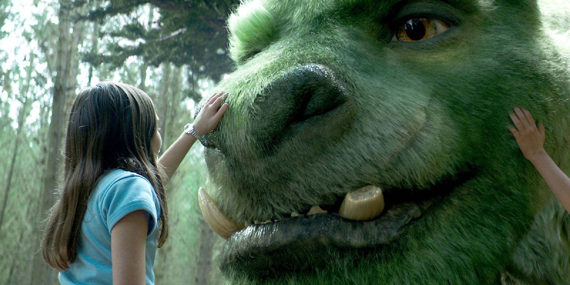 A child strokes a computer dragon in Pete's Dragon.