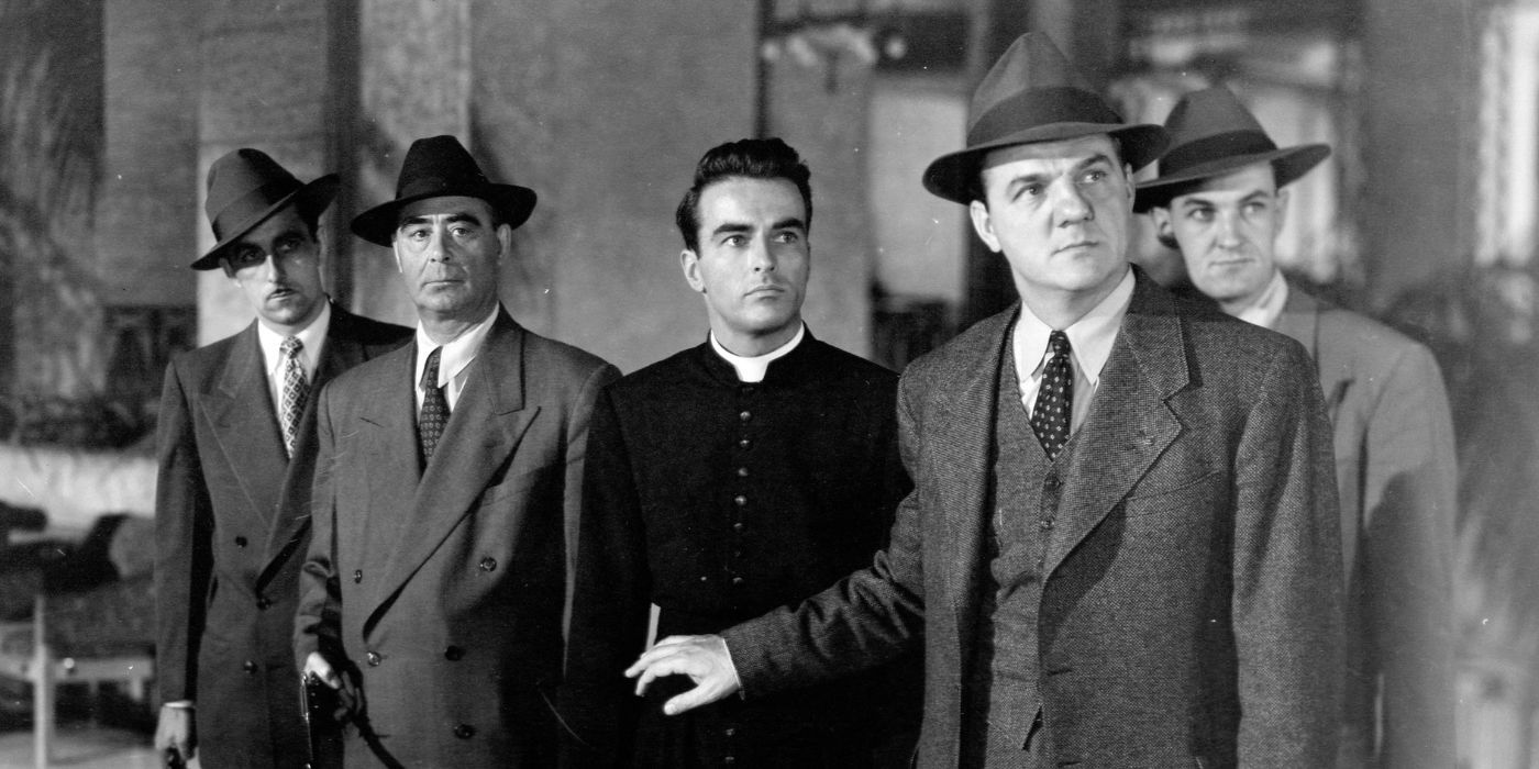 Montgomery Clift stands behind Karl Malden with several other men in I Confess.