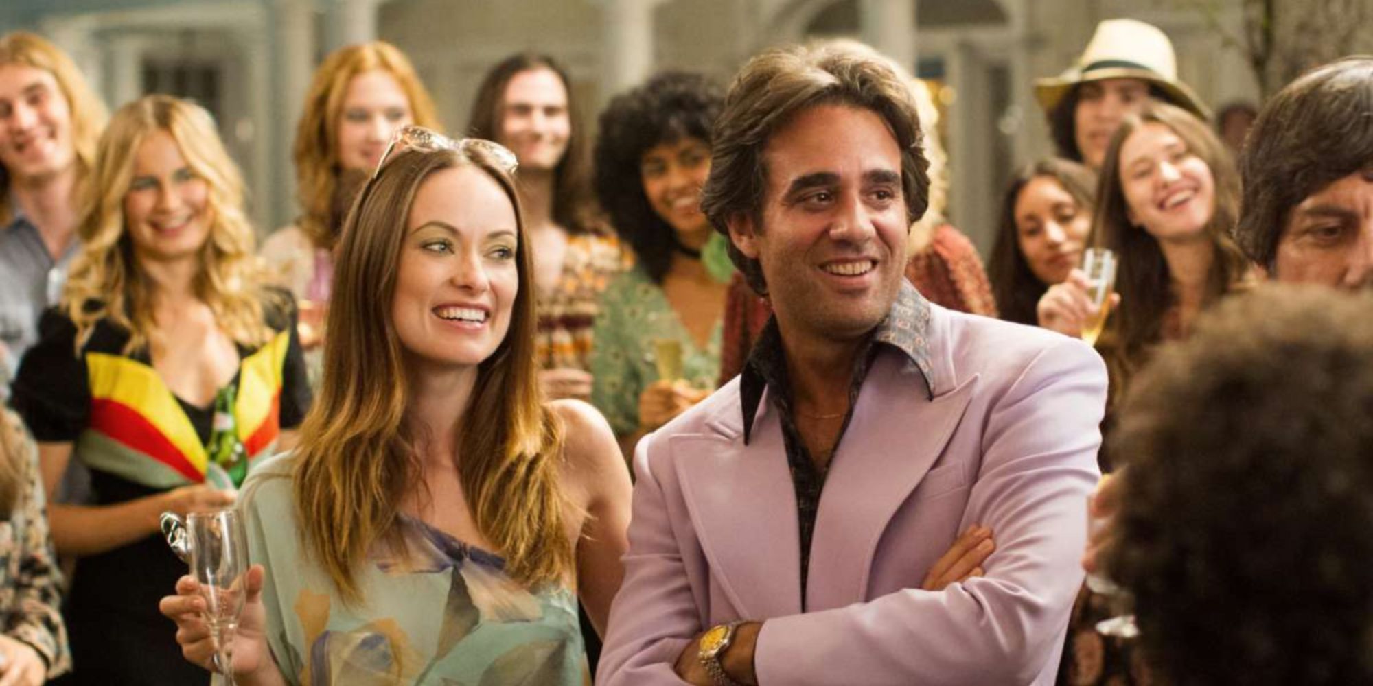 Richie and Devon smile at a party surrounded by people in vinyl.