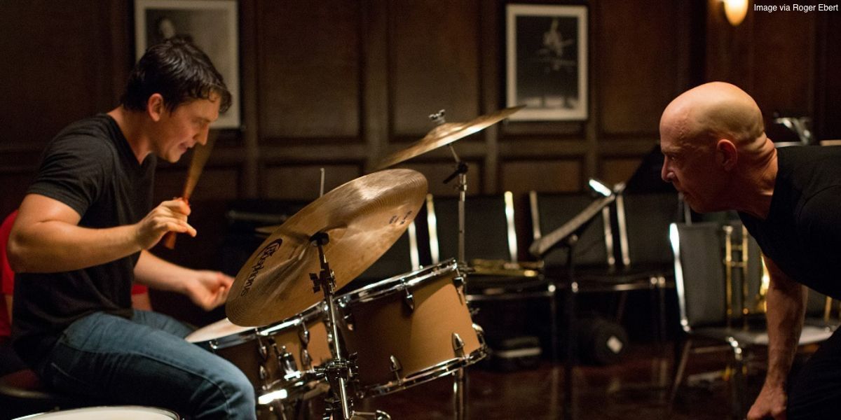 Andrew plays drums while Fletcher watches Whiplash.