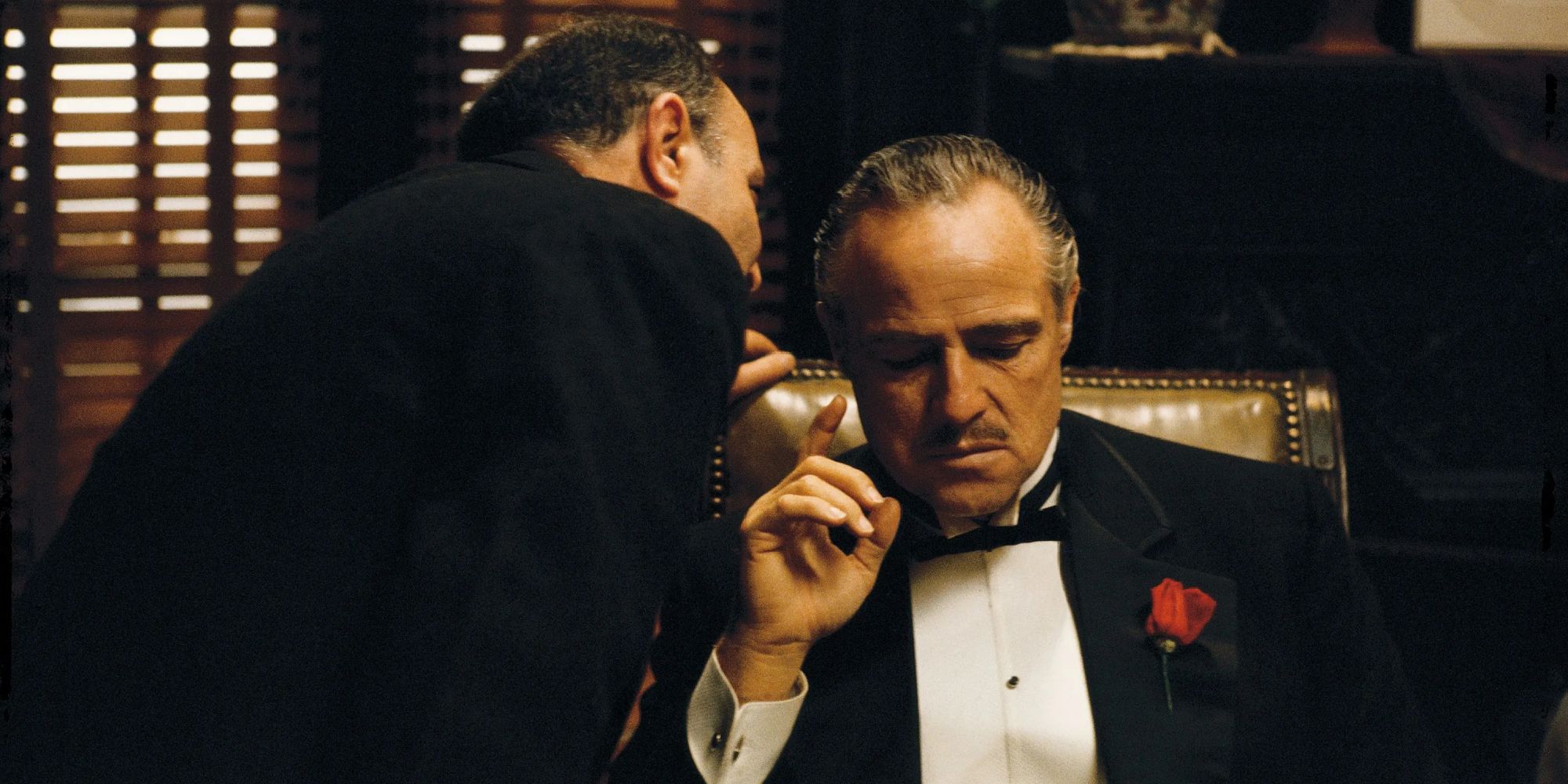 A man whispers in the ear of the mafia Don