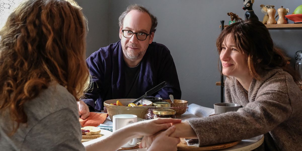 Kylie Carter as Sadie, Paul Giamatti as Richard, Kathryn Hahn as Rachel seated at a table on Netflix's Private Life.