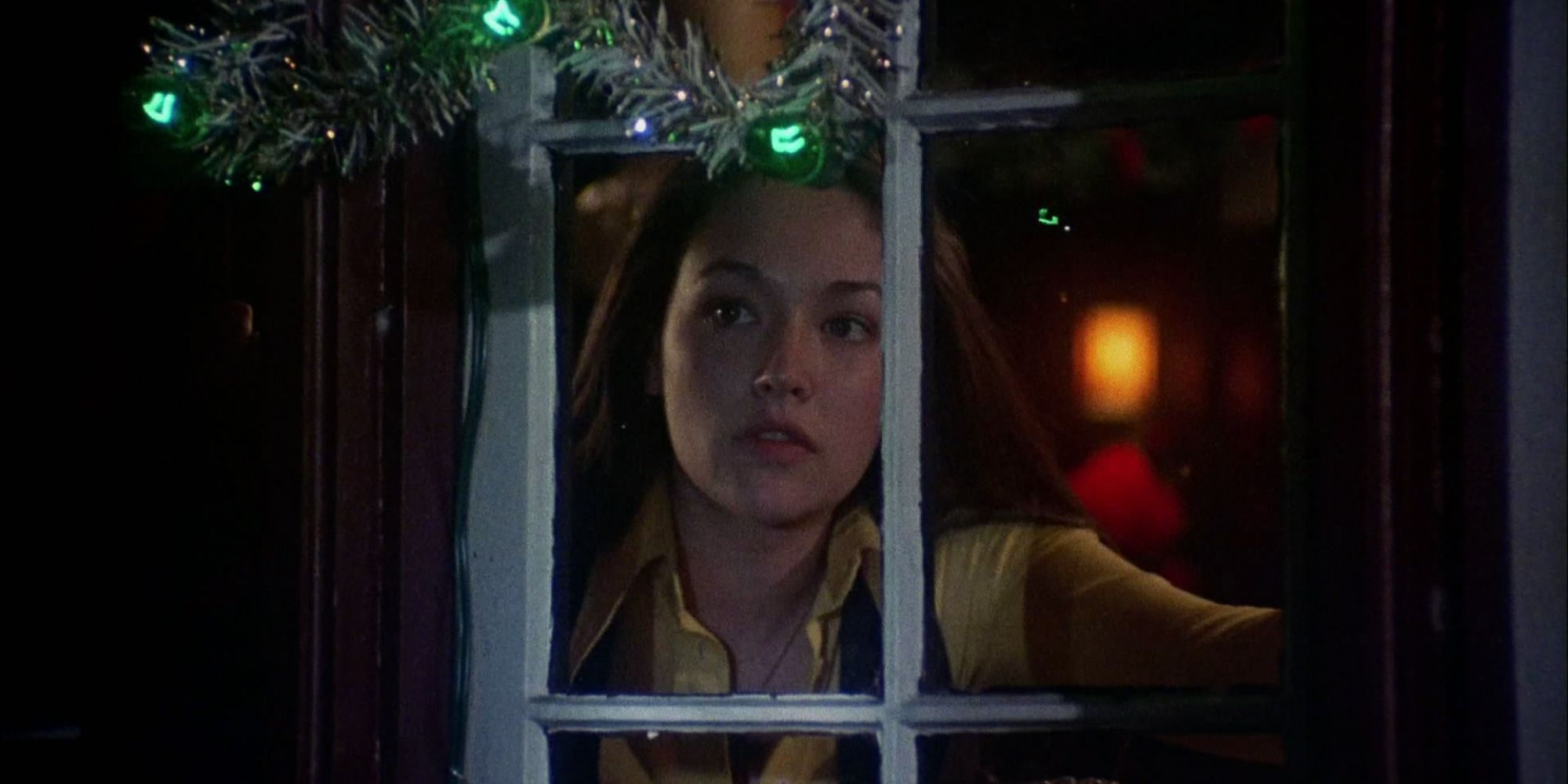 Olivia Hussey carefully looks out the window in Black Christmas.