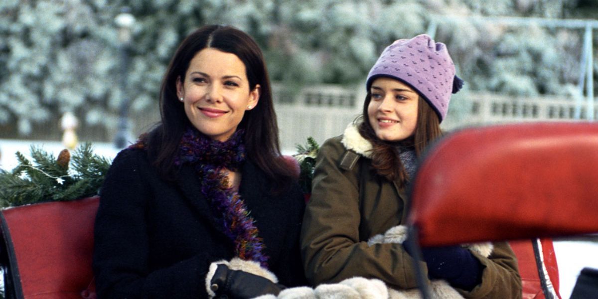 Lorelai and Rory sledding through the snow in Gilmore Girls.
