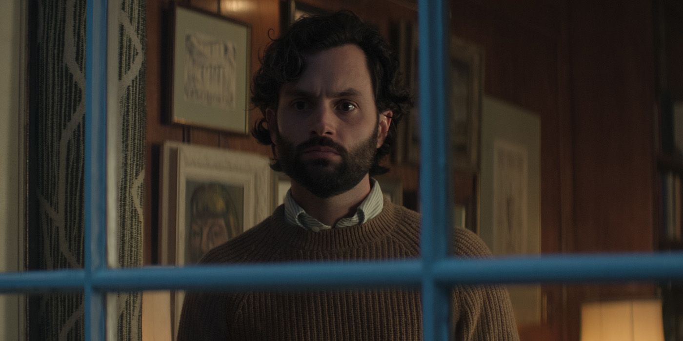 Penn Badgley as Joe Goldberg looks out the window of his apartment in Season 4 of You.