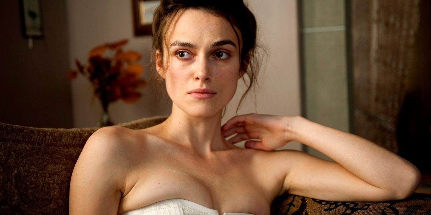Sabina Spielrein sits on the couch and stares at someone off-screen in A Dangerous Method.