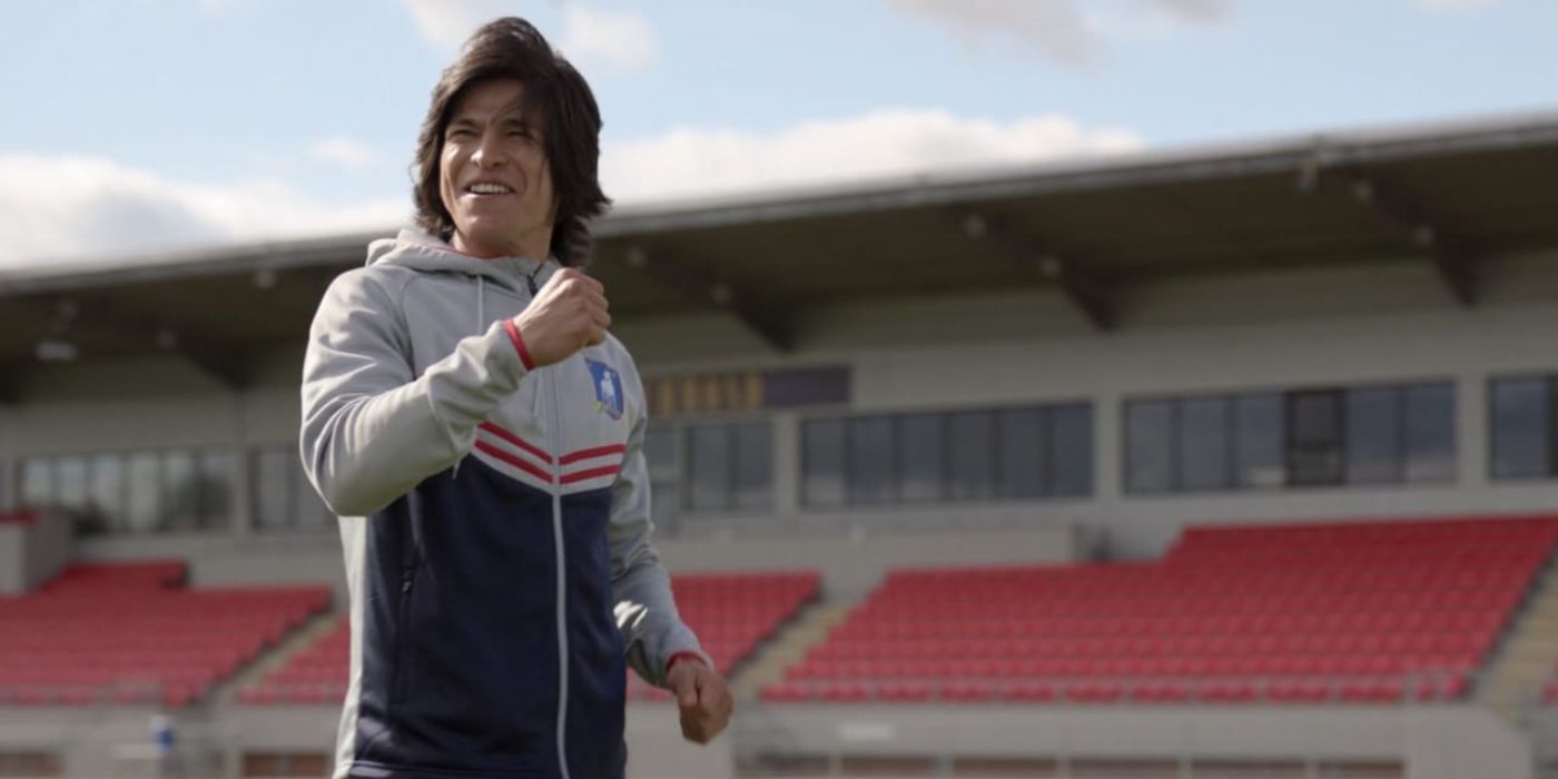 Dani Rojas (Cristo Fernandez) smiles on the pitch, raising his fist at Ted Lasso.