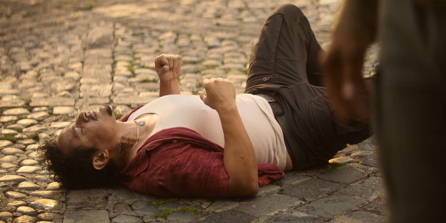 A still from Mother, featuring Jesse Garcia's Tarantula lying on the ground in pain and disappointment.