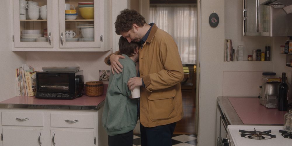 Sophia Lillis and Michael Cera hug in the kitchen in Grown Ups.